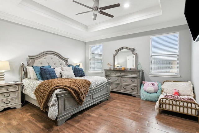 bedroom featuring ceiling fan, ornamental molding, and a raised ceiling