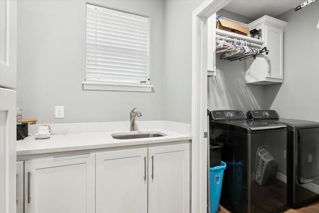 laundry room featuring sink, washer and clothes dryer, and cabinets