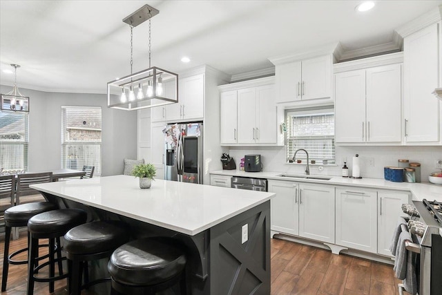 kitchen featuring white cabinetry, stainless steel appliances, sink, and pendant lighting