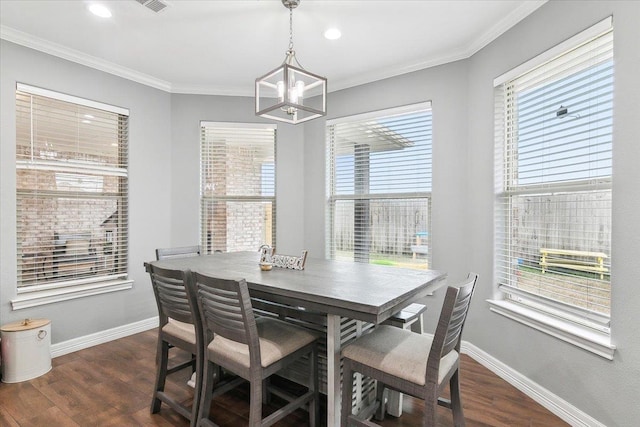 dining space with ornamental molding, plenty of natural light, an inviting chandelier, and dark hardwood / wood-style flooring