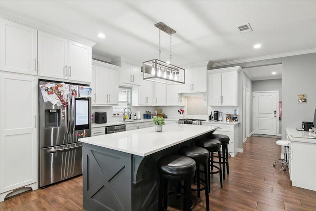 kitchen featuring sink, tasteful backsplash, decorative light fixtures, appliances with stainless steel finishes, and white cabinets