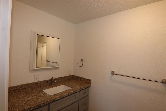 bathroom featuring a textured ceiling and vanity