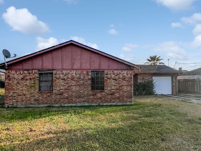 view of side of home featuring a garage and a lawn