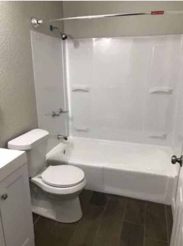 full bathroom with hardwood / wood-style floors, vanity, toilet, and washtub / shower combination