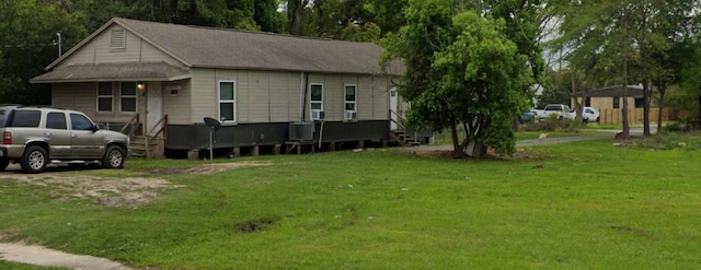 view of front of property featuring a front yard and cooling unit