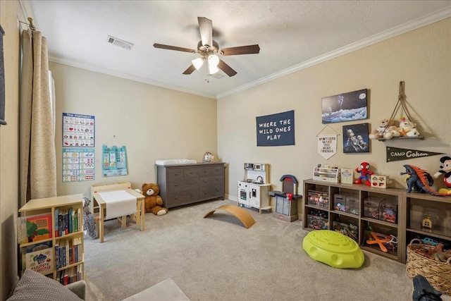 recreation room featuring carpet floors, a ceiling fan, visible vents, and ornamental molding