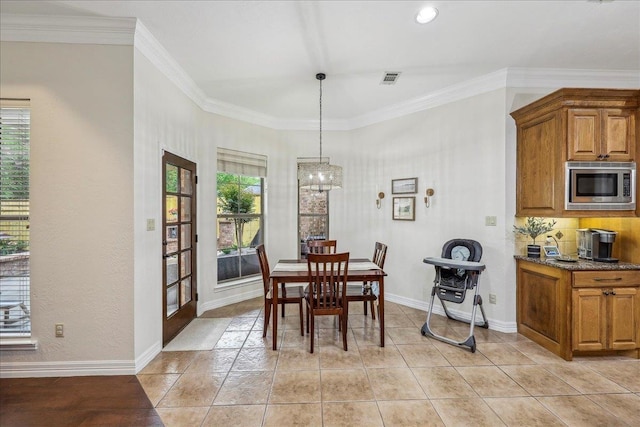 dining space featuring crown molding, baseboards, a notable chandelier, and visible vents