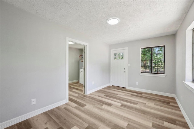 42252 State Highway 87, Orange, TX 77632 - spare room with light wood-style flooring, a textured ceiling, baseboards, and water heater