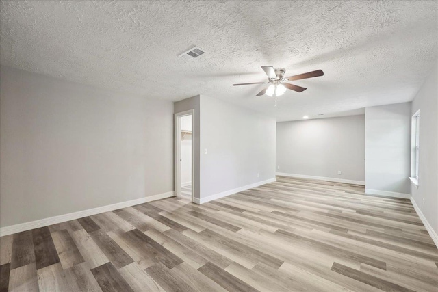 42252 State Highway 87, Orange, TX 77632 - unfurnished room with a ceiling fan, light wood-style flooring, baseboards, and a textured ceiling