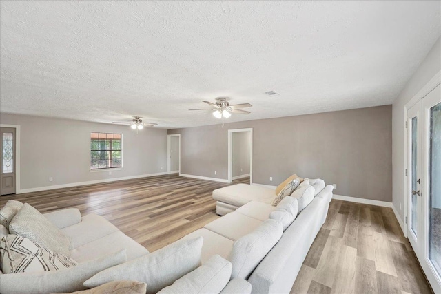 42252 State Highway 87, Orange, TX 77632 - living area featuring wood finished floors, a textured ceiling, baseboards, and a ceiling fan