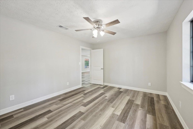 42252 State Highway 87, Orange, TX 77632 - empty room featuring wood finished floors, ceiling fan, baseboards, and a textured ceiling