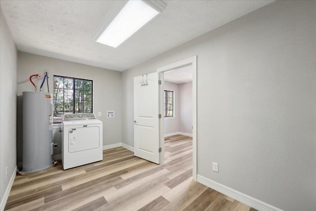 42252 State Highway 87, Orange, TX 77632 - laundry room featuring washer / clothes dryer, water heater, light wood finished floors, plenty of natural light, and a textured ceiling