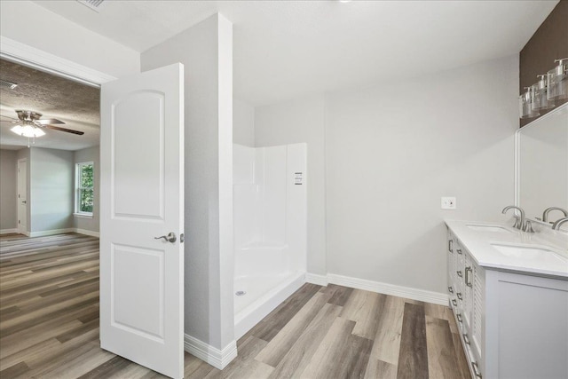 42252 State Highway 87, Orange, TX 77632 - full bathroom featuring wood finished floors, baseboards, and double vanity