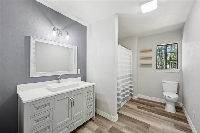 42252 State Highway 87, Orange, TX 77632 - bathroom featuring wood finished floors, toilet, vanity, baseboards, and curtained shower
