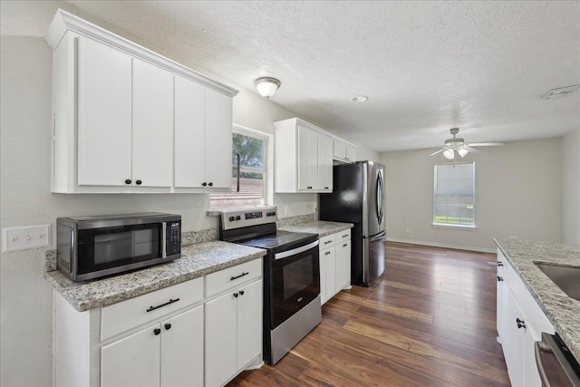664 W Tram Rd, Vidor, TX 77662 - kitchen with stainless steel appliances, dark wood-style floors, a ceiling fan, white cabinetry, and a textured ceiling