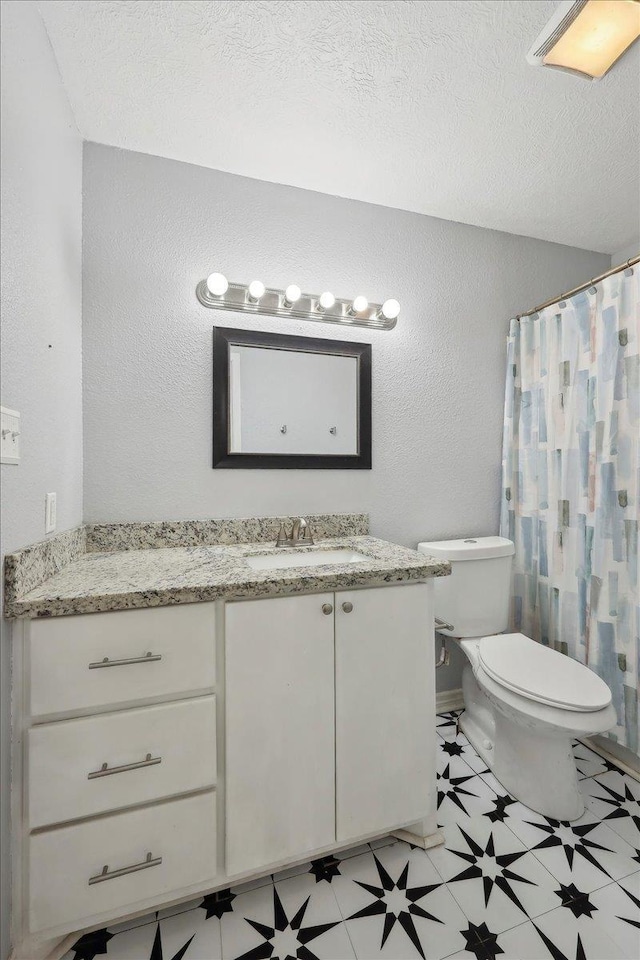 664 W Tram Rd, Vidor, TX 77662 - bathroom with toilet, vanity, a textured wall, tile patterned floors, and curtained shower