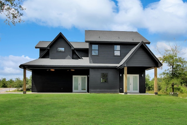 back of property featuring french doors and a lawn