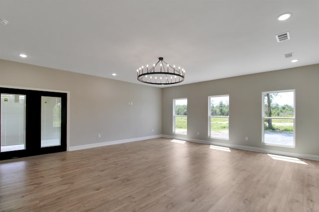 unfurnished room with light hardwood / wood-style floors and a chandelier