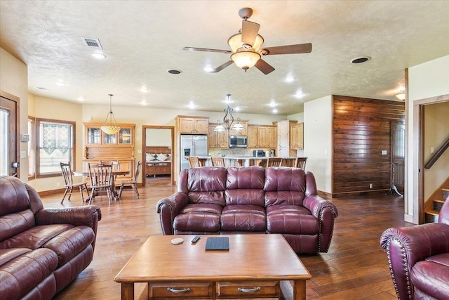 living room with ceiling fan, wood-type flooring, and a textured ceiling