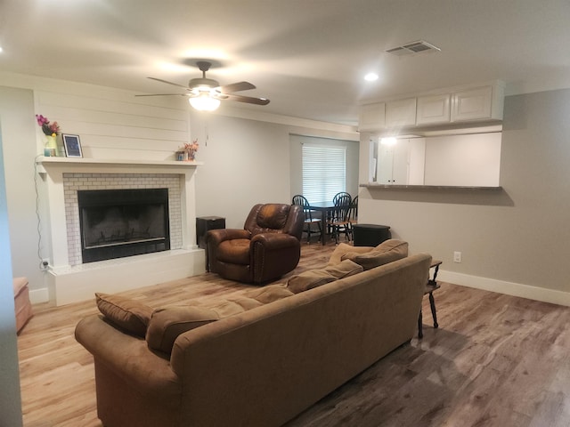 10848 Sandy Ln, Beaumont, TX 77705 - living area featuring wood finished floors, a ceiling fan, a fireplace with raised hearth, and recessed lighting