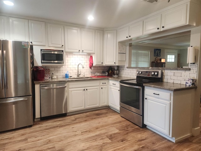 10848 Sandy Ln, Beaumont, TX 77705 - kitchen with stainless steel appliances, white cabinets, decorative backsplash, dark countertops, and recessed lighting