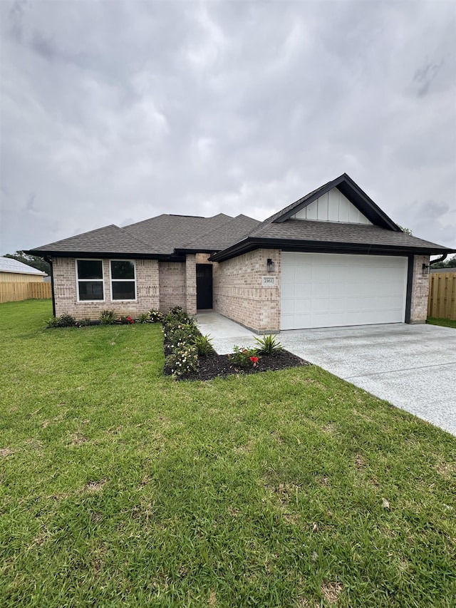 view of front of house with a garage, a front lawn, fence, brick siding, and driveway