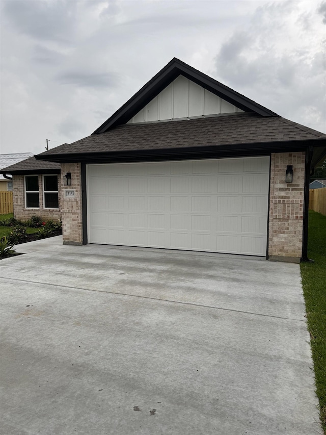 view of front of home featuring an attached garage, driveway, and brick siding