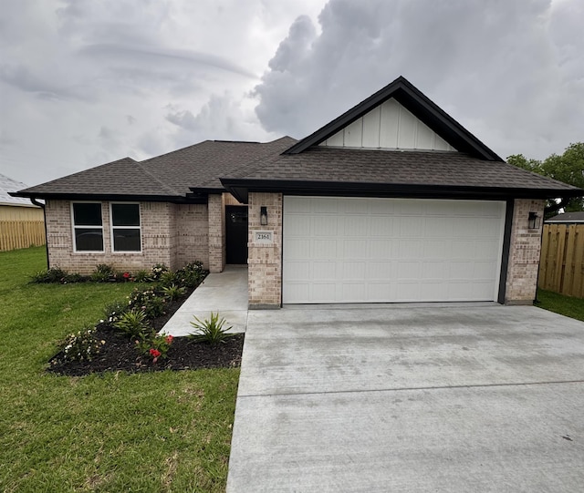 view of front of property with a front yard, a garage, brick siding, fence, and concrete driveway