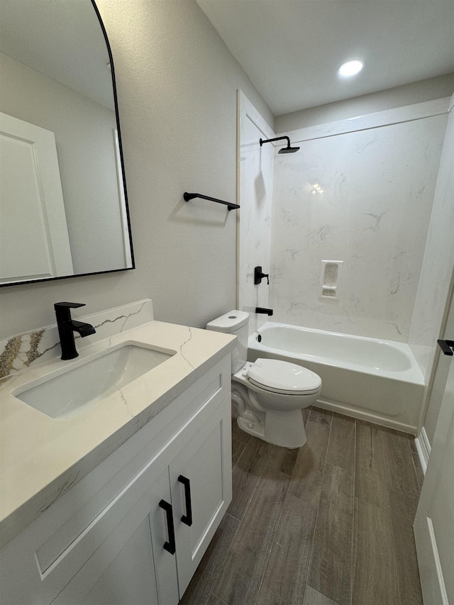 bathroom featuring vanity, shower / bathing tub combination, wood finished floors, and toilet