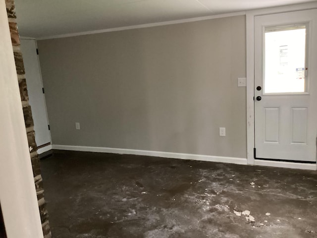 entryway featuring baseboards, crown molding, and concrete flooring