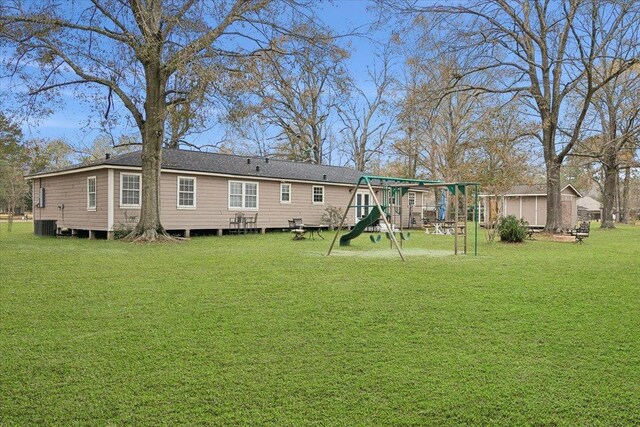 back of property with a playground and a lawn