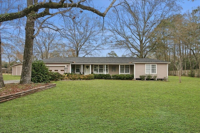 ranch-style home with a front yard, fence, and an attached garage