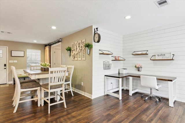 dining room with visible vents, wood finished floors, and a textured ceiling