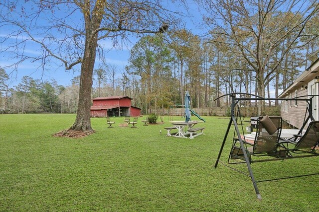 view of yard featuring an outbuilding, fence, and a playground