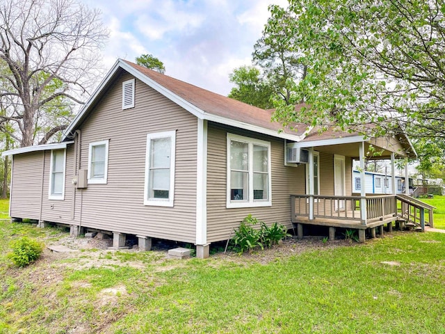 back of property featuring a yard and an AC wall unit