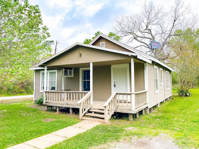 bungalow-style home with covered porch and a front lawn