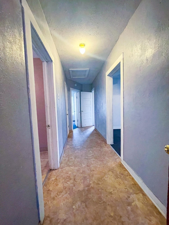 corridor featuring a textured ceiling