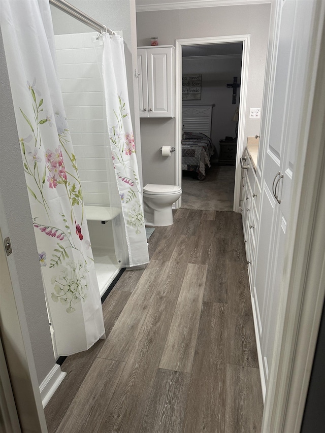 bathroom with a shower with curtain, wood-type flooring, and toilet