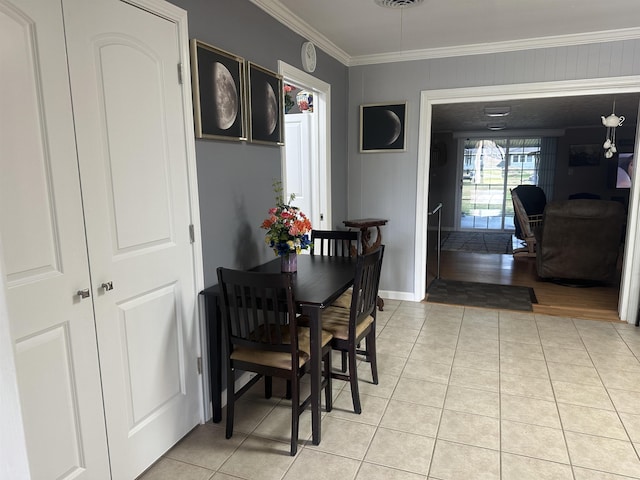 tiled dining room featuring crown molding