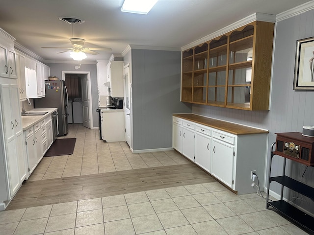 kitchen with light tile patterned floors, crown molding, ceiling fan, independent washer and dryer, and white cabinets