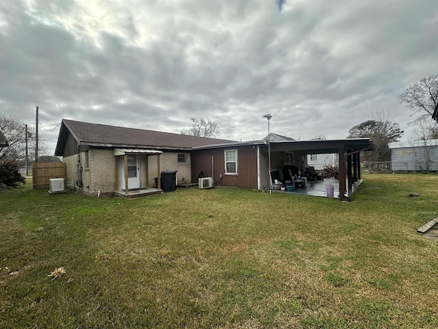 rear view of property with cooling unit, a patio area, and a lawn