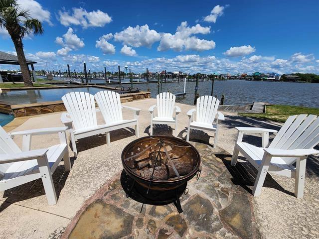 view of patio / terrace with a boat dock, a water view, and an outdoor fire pit