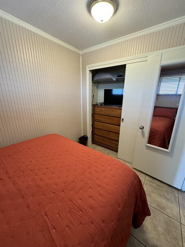 tiled bedroom with crown molding and a textured ceiling