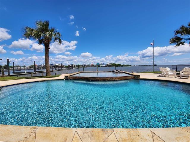 view of swimming pool with a patio area and a water view