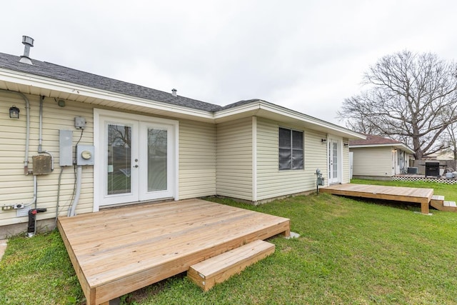 rear view of house with a yard, french doors, and a wooden deck