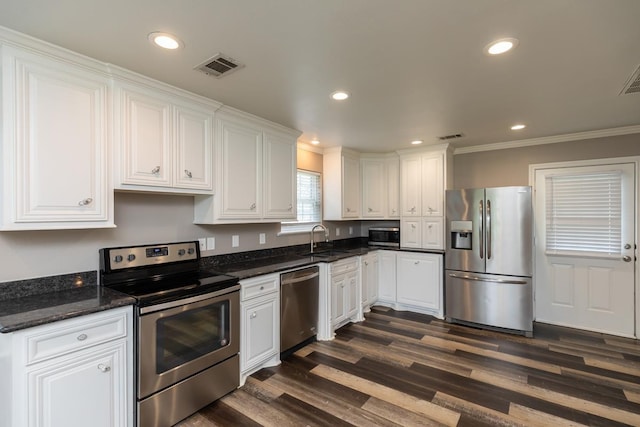 3075 Shivers St, Vidor, TX 77662 - kitchen featuring stainless steel appliances, a sink, white cabinetry, crown molding, and dark wood-type flooring