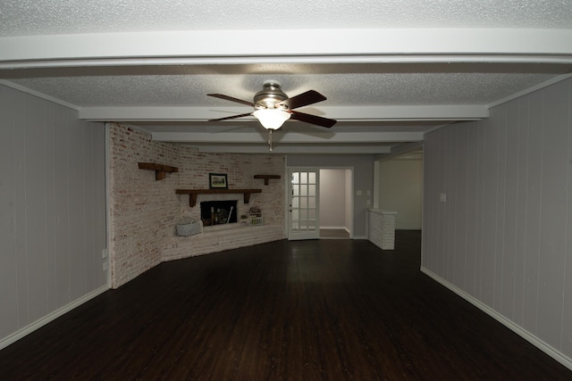 unfurnished living room with beamed ceiling, ceiling fan, dark hardwood / wood-style floors, and a fireplace