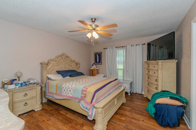 bedroom with a textured ceiling, ceiling fan, and dark hardwood / wood-style floors