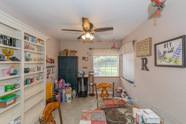 interior space with ceiling fan and a textured ceiling