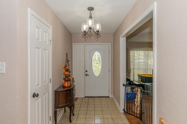 foyer entrance featuring a textured ceiling and a chandelier